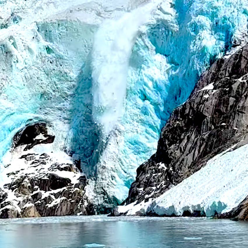 Alaska glacier landslide sending debris and waves crashing into a fjord